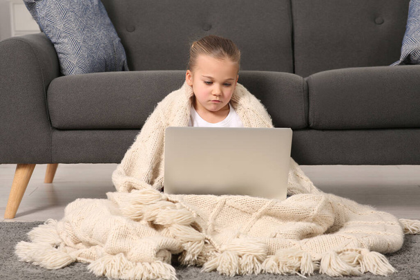 Little girl using laptop on floor at home. Internet addiction - Фото, зображення