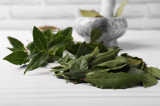 Fresh green bay leaves on white wooden table, closeup - Foto, Imagen