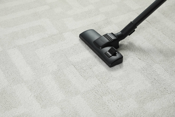 Hoovering white carpet with modern vacuum cleaner. Space for text - Valokuva, kuva