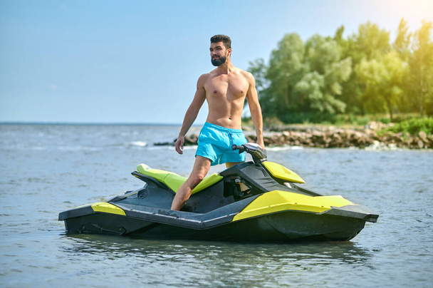 Young handsome man on jet ski on tropical ocean vacation enjoying holiday at resort active pastime. - Foto, Bild