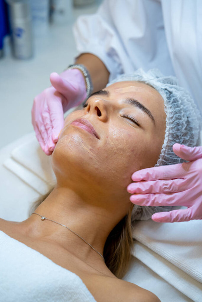 Female face getting microdermabrasion procedure in a beauty spa salon. Skin care treatment. - Foto, afbeelding