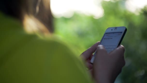 Mujer joven enviando un texto al aire libre
 - Metraje, vídeo