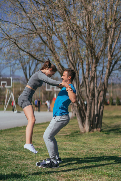 Прекрасная спортивная пара, развлекающаяся в парке - Фото, изображение