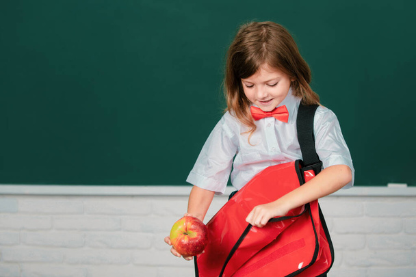 Portrait of cute, lovely, girl with backpack in school uniform in classroom. Kids education and knowledge. Student kids - Photo, image