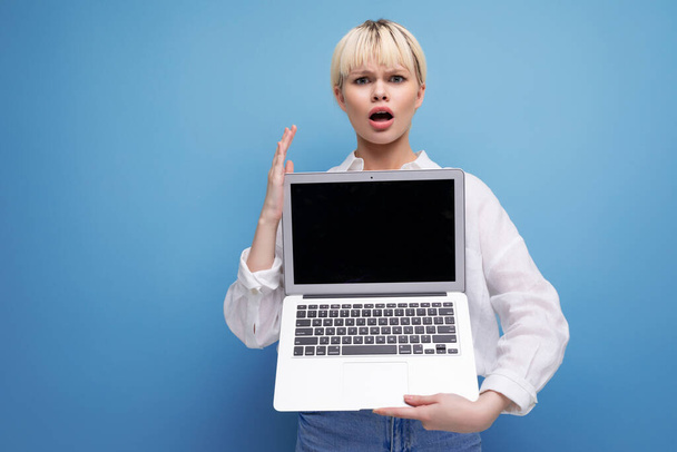 Porträt einer selbstbewussten jungen hübschen blonden Geschäftsfrau in weißer Bluse, die ihr Projekt auf einem Laptop-Bildschirm mit Attrappe demonstriert. Geschäftskonzept. - Foto, Bild
