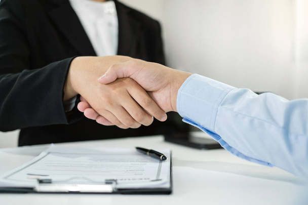 Φιλικοί επιχειρηματίες και στελέχη σφίγγουν το χέρι μετά από επιτυχή συμφωνία με τις συμβάσεις εργασίας, τις προσλήψεις και τις έννοιες απασχόλησης. - Φωτογραφία, εικόνα