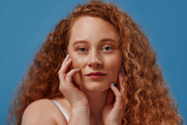 Redhead with freckles young plump plus size woman in white lingerie isolated on blue background. Body positive, skin care and cosmetology. - Photo, Image