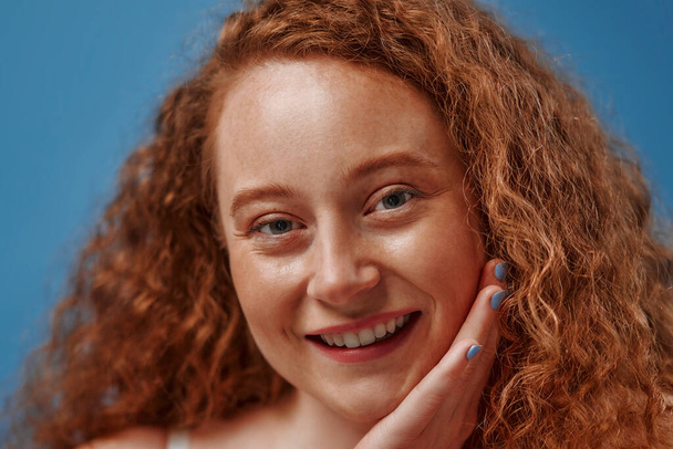 Redhead with freckles young plump plus size woman in white lingerie isolated on blue background. Body positive, skin care and cosmetology. - 写真・画像