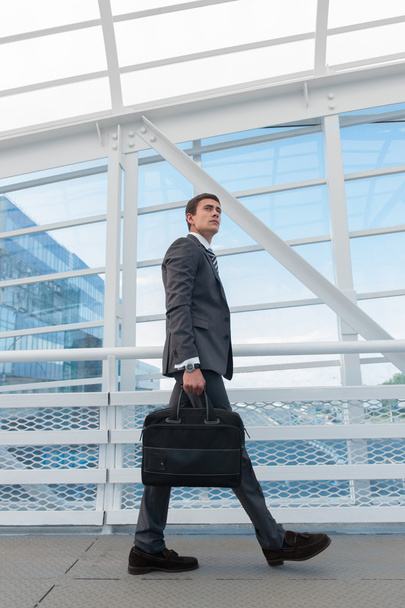 Businessman walking in urban environment - Фото, изображение