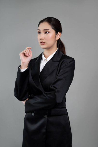 若い実業家を自信を持って孤立した背景に立って、正式な黒いスーツを着ている。スマートかつ専門的な外観を持つオフィスの女性やマネージャー。熱狂的。 - 写真・画像