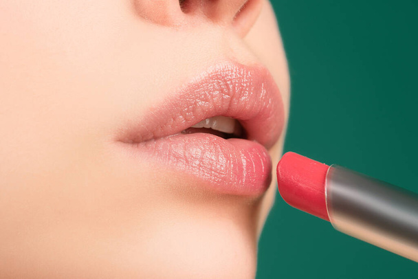 Lips lipstick closeup. Applying makeup on lip. Pampering, lips correction concept - Foto, afbeelding