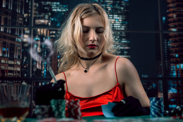 girl  holding a cigar and playing poker at casino. Gambling - Zdjęcie, obraz