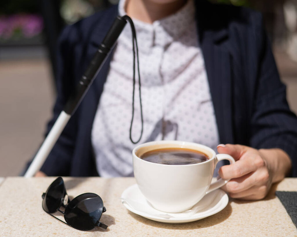 Blind woman in business suit drinking coffee in outdoor cafe - Foto, Imagem