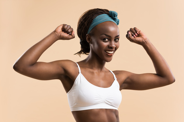 Athletic girl posing and showing muscles - Valokuva, kuva