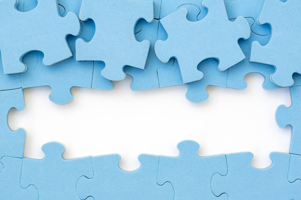 Four blue puzzle pieces revealing white background. Business, teamwork solution concept. Copy space. - 写真・画像