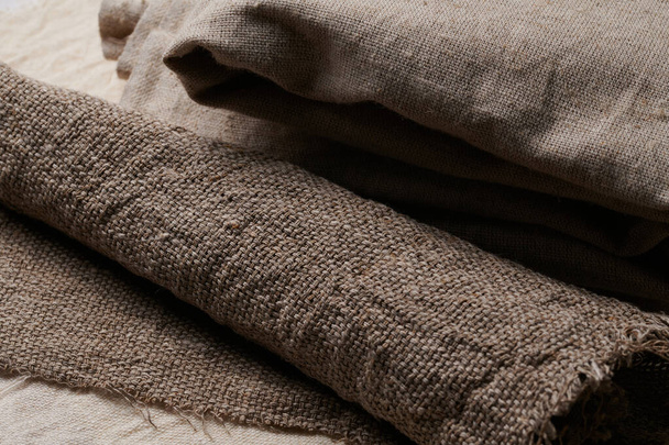 Linen in different textures and colors. Natural fabrics from organic flax and cotton in rolls, homespun textile handmade. Burlap and canvas for eco, rustic, boho, hygge decor - Photo, Image