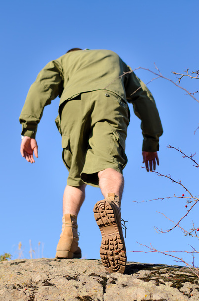 Vista posteriore di un boy scout che cammina sulla cima di una roccia
 - Foto, immagini