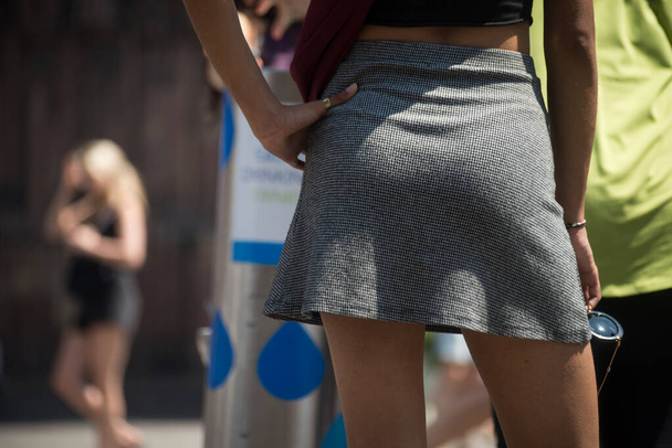 Closeup of young woman wearing a mini skirt standing in the street - Фото, зображення