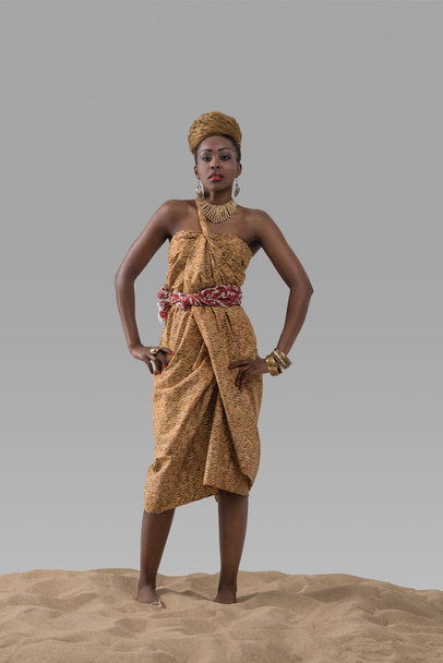 African fashion woman standing on sand - Fotó, kép