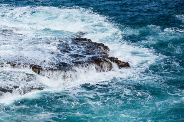La mer qui fait rage coule sur les roches d'esclaves sur le rivage
 - Photo, image