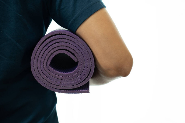 Young woman holding a yoga mat in exercise class for a sport and healthy concept - Foto, afbeelding