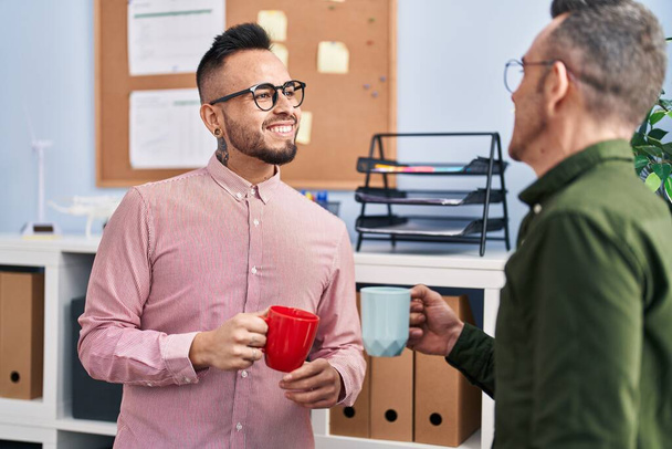 Dva muži obchodní pracovníci usměvaví sebevědomě pít kávu v kanceláři - Fotografie, Obrázek