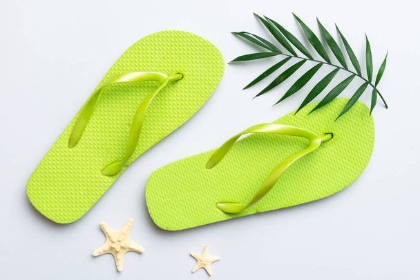Flat lay composition with flip flops and seashell on colored background. Space for text top view. - Φωτογραφία, εικόνα