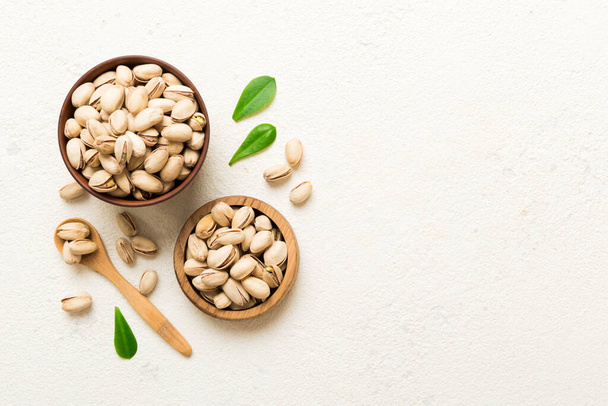 Fresh healthy Pistachios in bowl on colored table background. Top view. Healthy eating concept. Super foods. - Foto, afbeelding