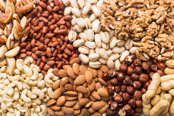 different nuts background. Close up, top view, flat lay. Walnut, pistachios, almonds, hazelnuts and cashews - Φωτογραφία, εικόνα