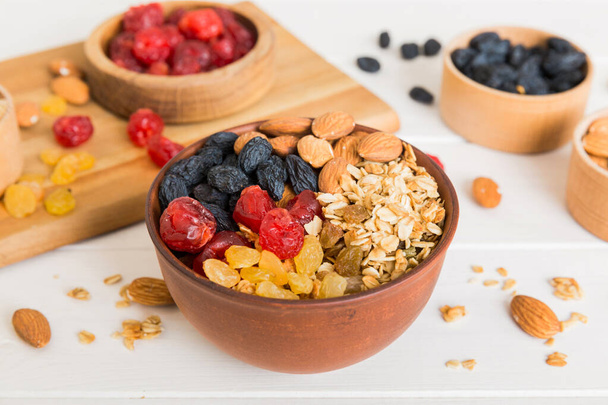 Cooking a wholesome breakfast. Granola with Various dried fruits and nuts in a bowl. The concept of a healthy dessert. Flat lay, top view with copy space. - Photo, Image