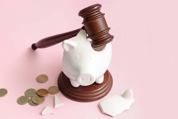Broken piggy bank with judge gavel and money on pink background. Bankruptcy concept - Foto, imagen