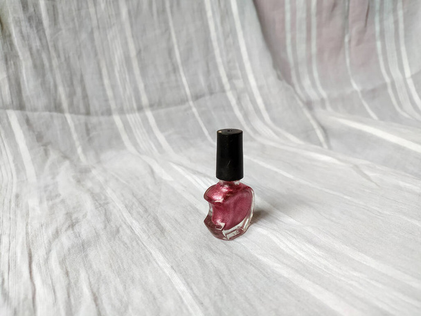 A photo of A pink nail polish with a unique half heart shaped bottle - Fotografie, Obrázek