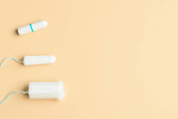 Diferentes tampones menstruales sobre fondo beige - Foto, imagen