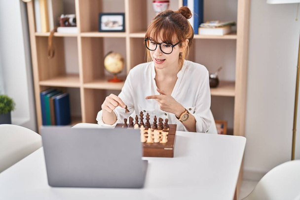 Young woman playing online chess game at home - Foto, Imagem