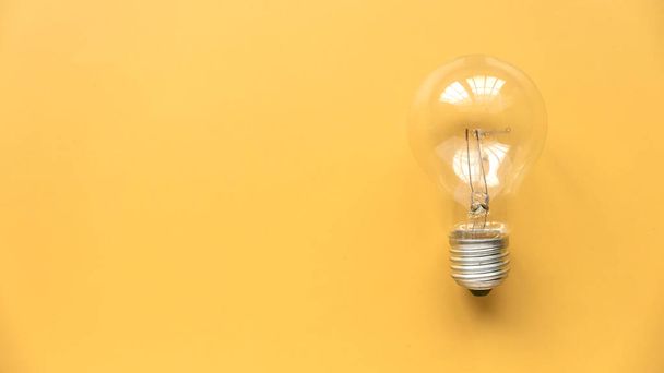 Creative thinking idea, innovation and inspiration concept. Bulb on yellow background. Copy space. - Zdjęcie, obraz