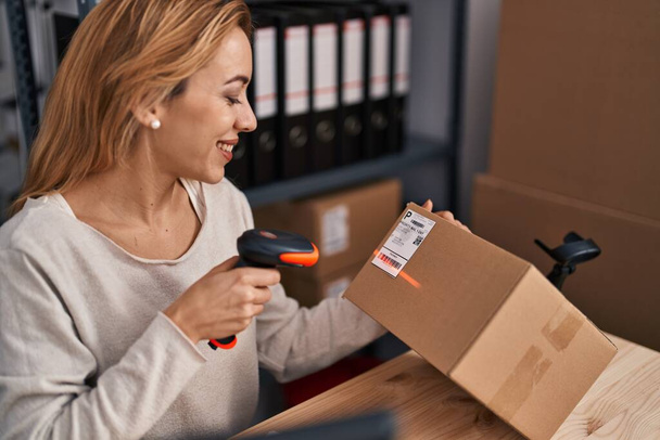 Young woman ecommerce busines worker scanning package at office - Photo, Image