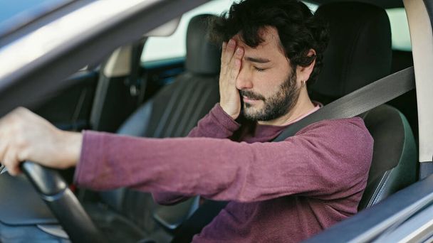 Joven hispano estresado conduciendo coche en la calle - Foto, imagen