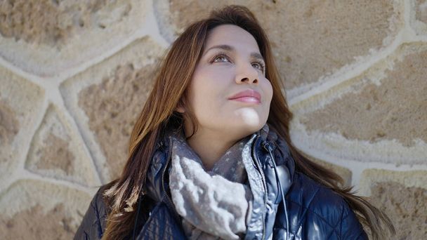 Молода красива іспанська жінка дивиться в небо на вулиці
 - Фото, зображення