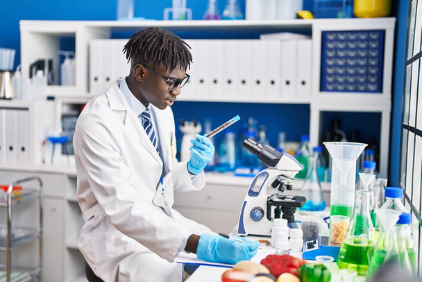 Afrikaanse amerikaanse man wetenschapper praten op smartphone met peper in het laboratorium - Foto, afbeelding