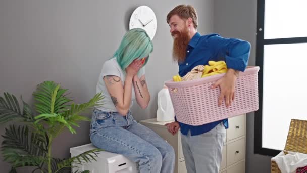 男性と女性カップルは,洗濯室でキスをする服でバスケットを持っています - 映像、動画
