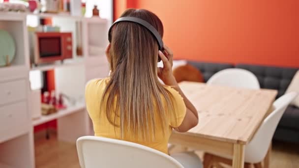 Moyen-Orient femme écouter de la musique assis sur la table dansant à l'envers à la salle à manger - Séquence, vidéo