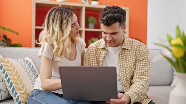 mężczyzna i kobieta para za pomocą laptopa siedzi na kanapie w domu - Zdjęcie, obraz