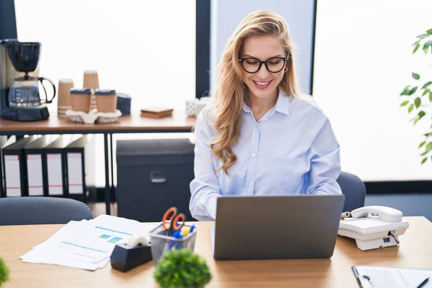 Mujer joven rubia trabajadora de negocios usando laptop trabajando en la oficina - Foto, Imagen