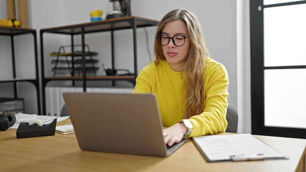 Mujer joven rubia trabajadora de negocios usando laptop trabajando en la oficina - Foto, imagen