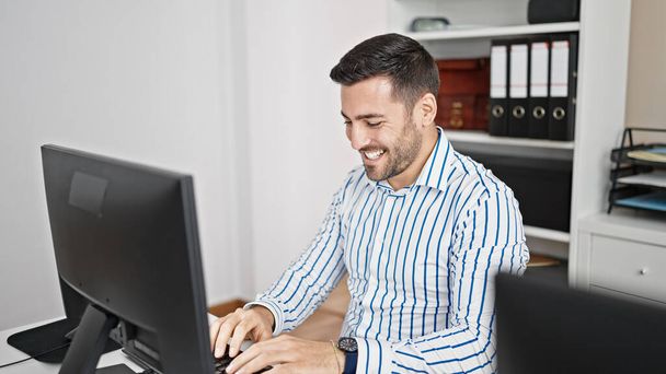 Young hispanic man business worker using computer working at office - Foto, imagen