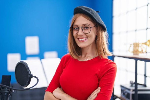 Jeune rousse artiste femme souriante confiante debout avec les bras croisés geste au studio de musique - Photo, image