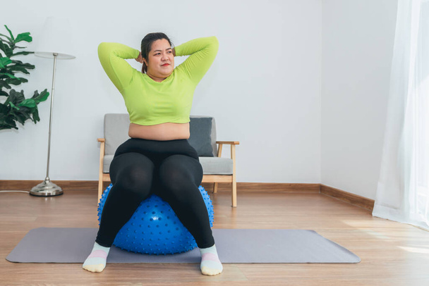 Retrato de imágenes de la mujer gorda asiática sonrisa y sentado en una pelota de ejercicio azul, para hacer ejercicio en casa para la salud y el concepto de pérdida de peso. - Foto, Imagen