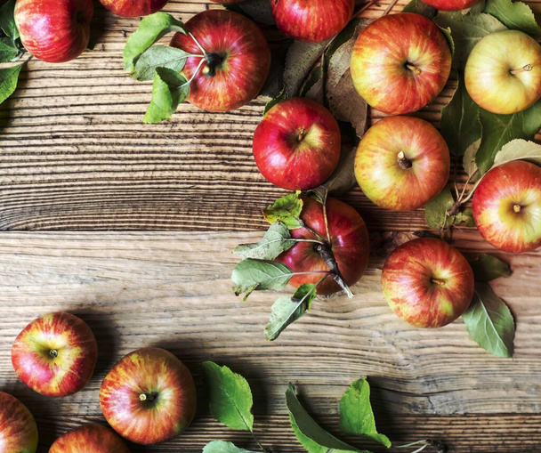 Rode appels en bladeren achtergrond - Foto, afbeelding
