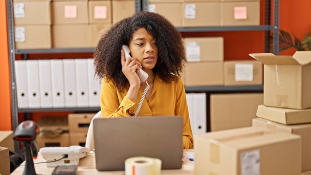 Африканская американская женщина электронной коммерции бизнес-работник с помощью ноутбука говорить по телефону в офисе - Фото, изображение