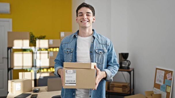 Młody latynoski człowiek e-commerce pracownik biznesu posiadających pakiety w biurze - Zdjęcie, obraz